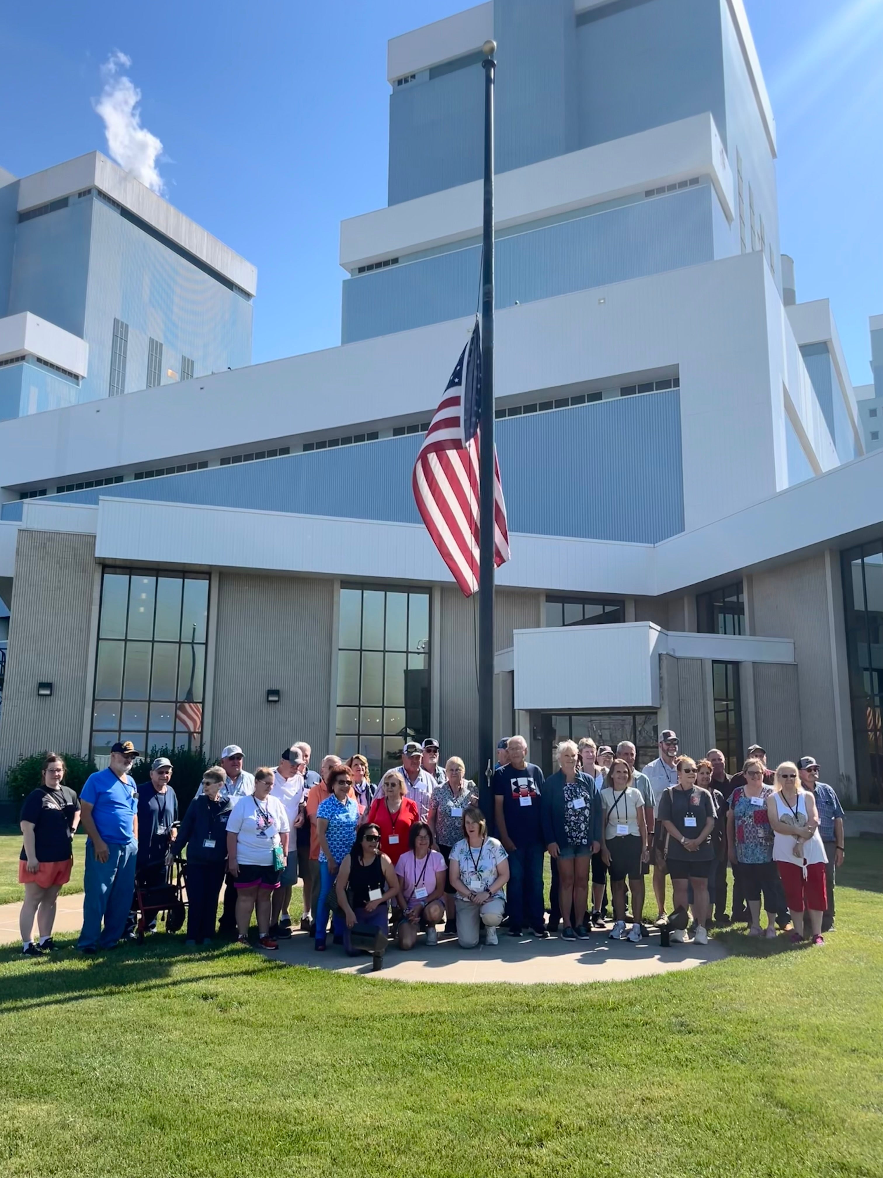 Members on the tour pose for a group photo in front of Antelope Valley Station, where coal is turned into electricity