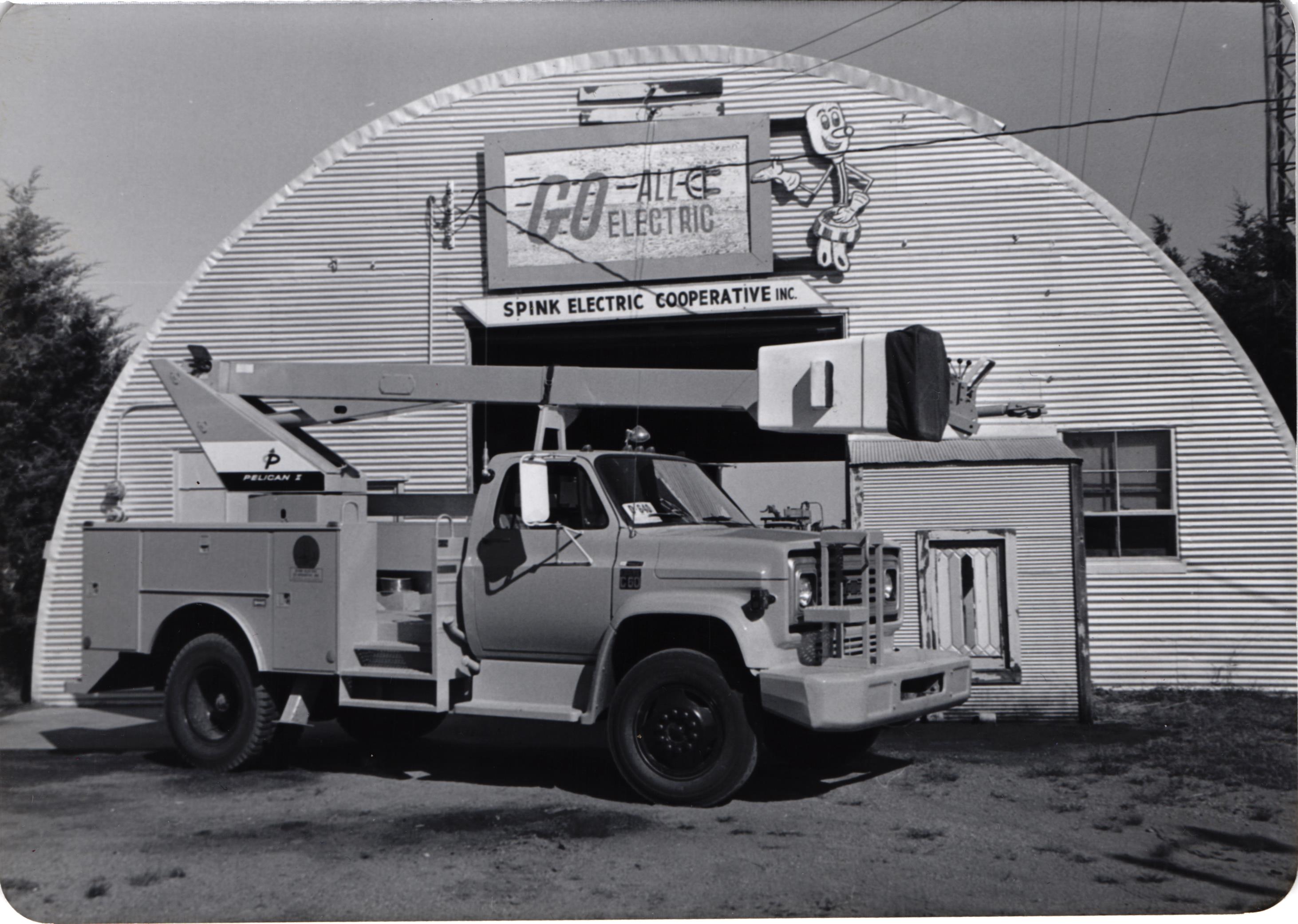 A black and white photo of Spink Electric shop and bucket truck from the 1980's